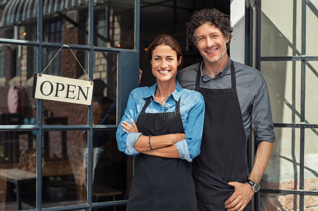 Small Montgomery County business owners couple standing in front of door